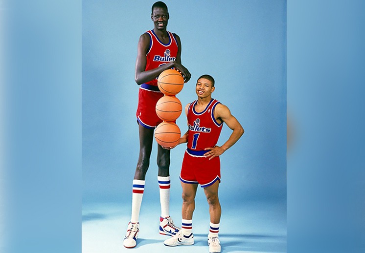 Manute Bol junto a Muggsy Bogues, el jugador más bajo de la competición en la historia.